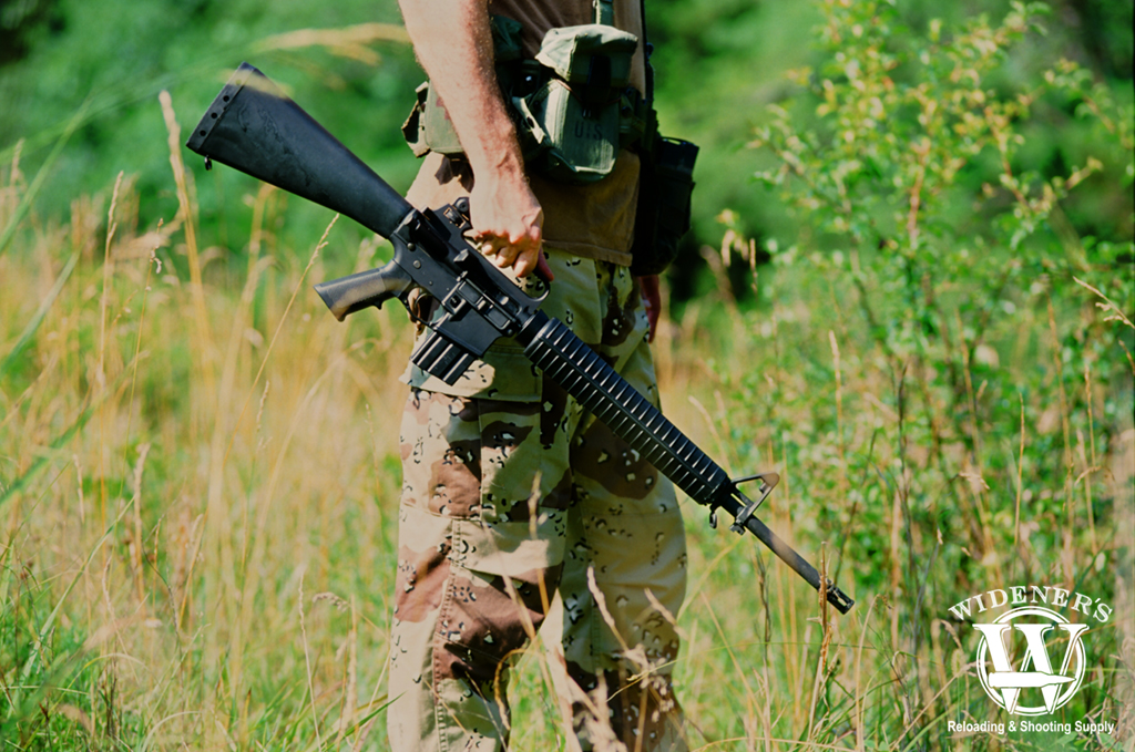 a photo of a man holding a Colt M16A2 captured on a Nikon F3 camera