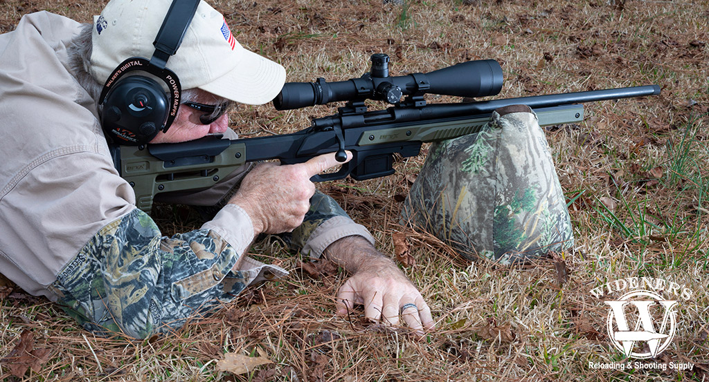 a photo of a man shooting a bolt action rifle