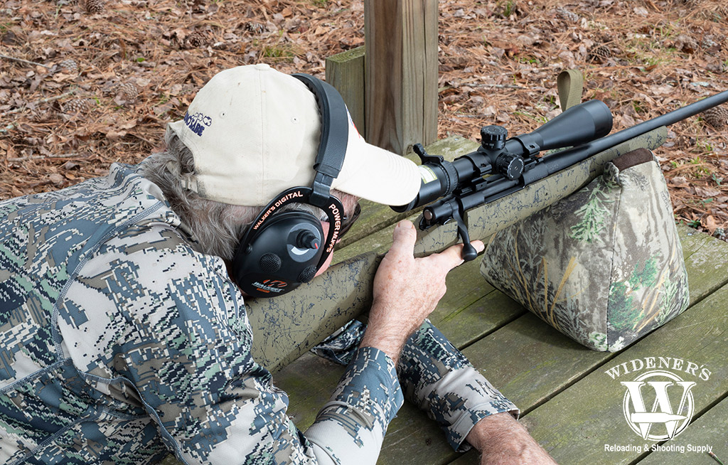 a photo of a man shooting a bolt action rifle and centerfire ammo