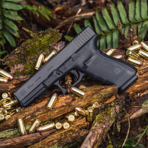 photo of a glock 21 45 acp handgun outdoors with ammo