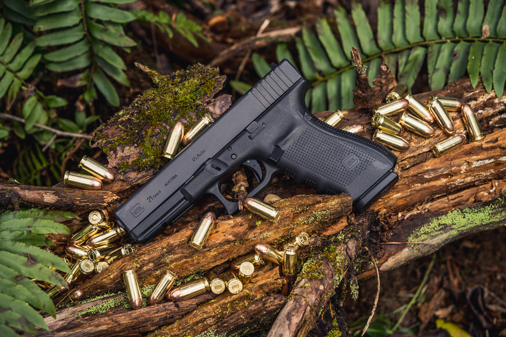 photo of a glock 21 45 acp handgun outdoors with ammo