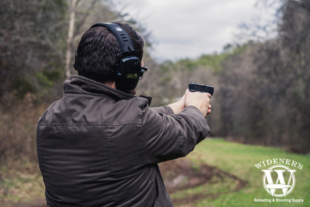 a photo of a man shooting a glock 21 handgun