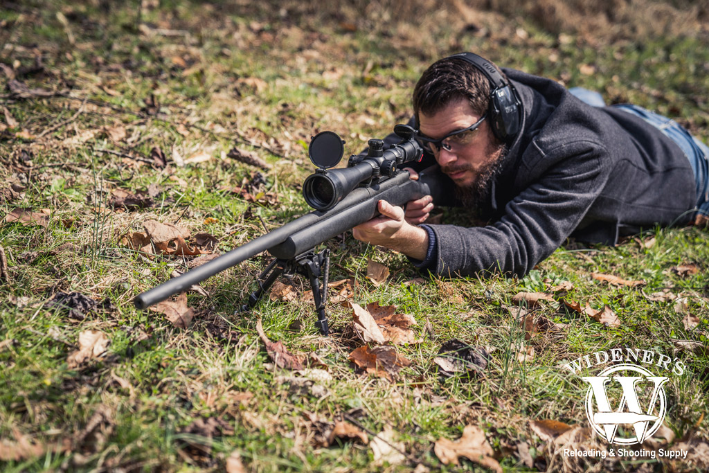 photo of a man shooting a hunting rifle outdoors