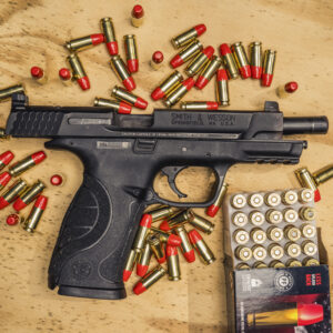photo of 9mm smith & wesson M&P pistol with federal syntech ammo on a sheet of plywood