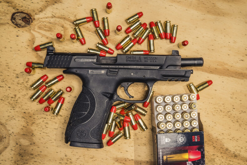 photo of 9mm smith & wesson M&P pistol with federal syntech ammo on a sheet of plywood