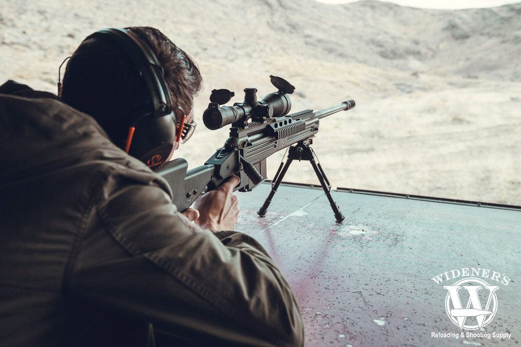 a photo of a man shooting a savage 110 BA bolt action rifle