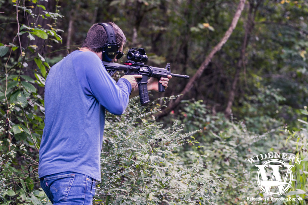 photo of a man in the woods shooting an ar15 rifle with 223 ammo illustrating the history of the ar-15