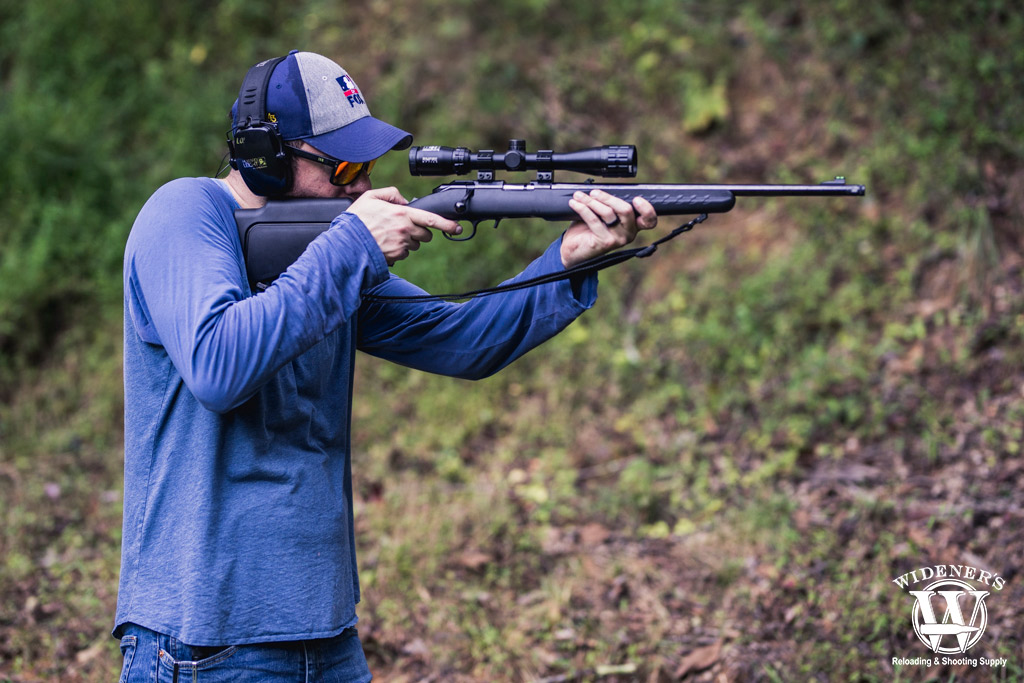 a photo of a man shooting a bolt action rifle