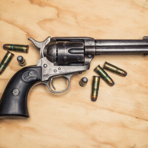 a photo of a colt navy revolver on plywood