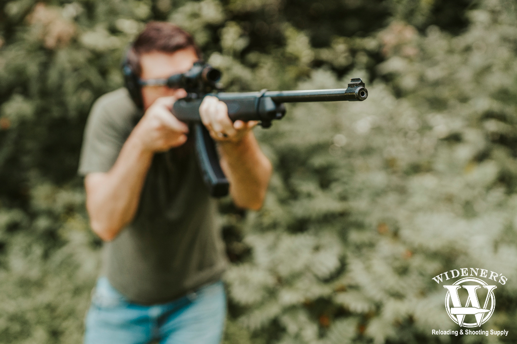 a photo of a man shooting a rimfire rifle