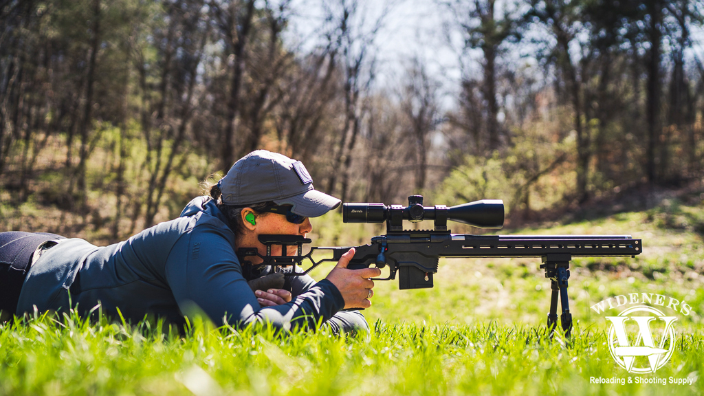 a photo of a woman shooting a bolt action rimfire rifle