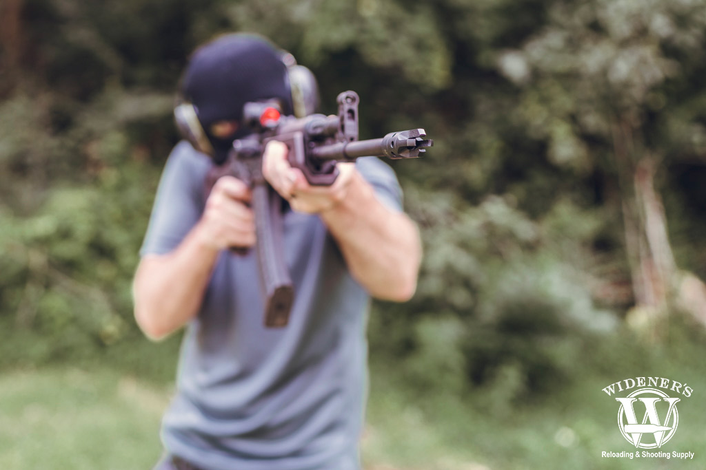 a photo of a man shooting an ak-47 semi auto rifle
