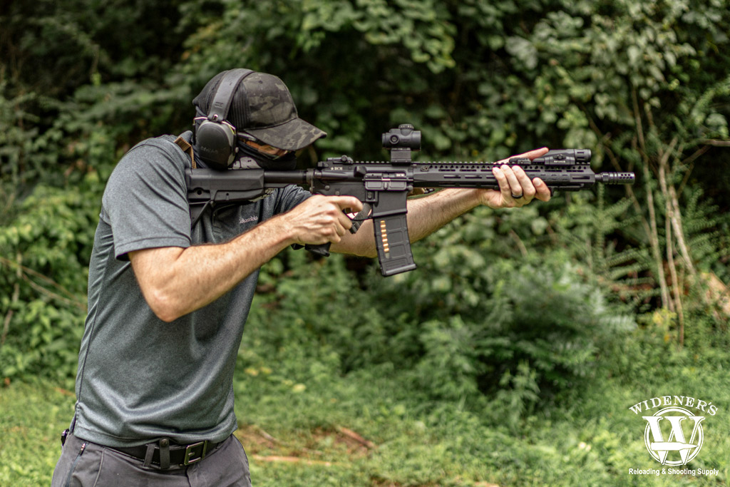 a photo of a man shooting an ar-15 semi auto rifle