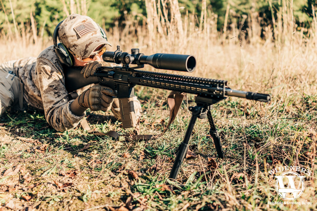 a photo of a man shooting recce rifle outdoors