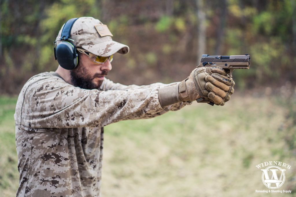 a photo of a man shooting a modular handgun system weapon