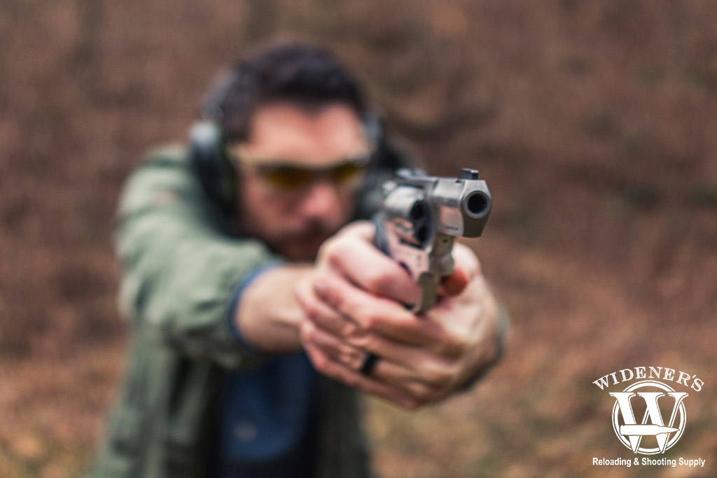 a photo of a man shooting a revolver at a gun range