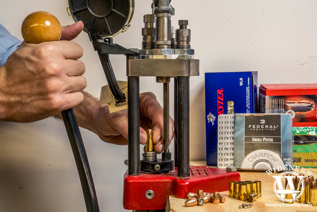 a photo of a man handloading ammo at a bench