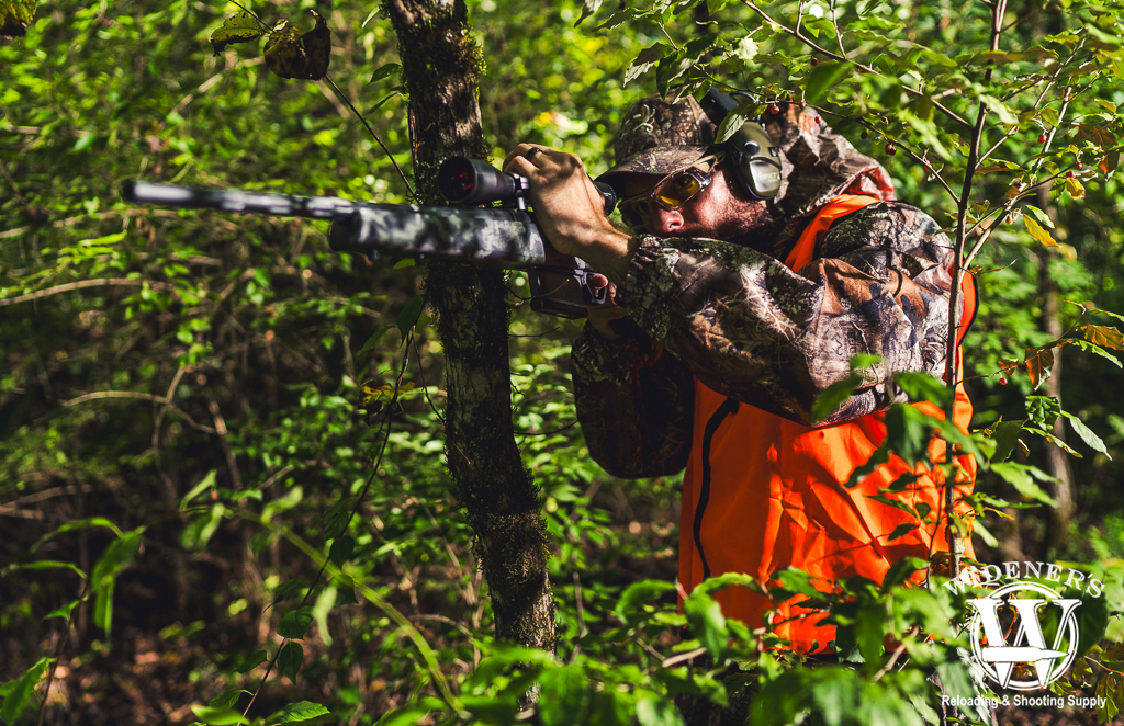 photo of a man shooting a hunting rifle outdoors