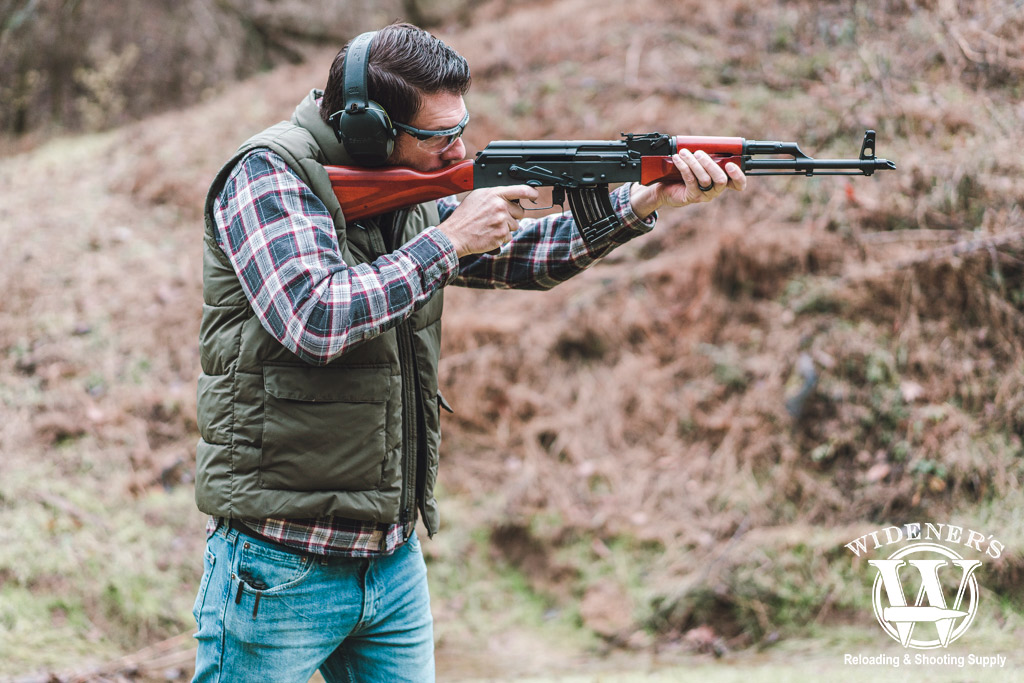 a photo of a man shooting an ak-47 at a gun range