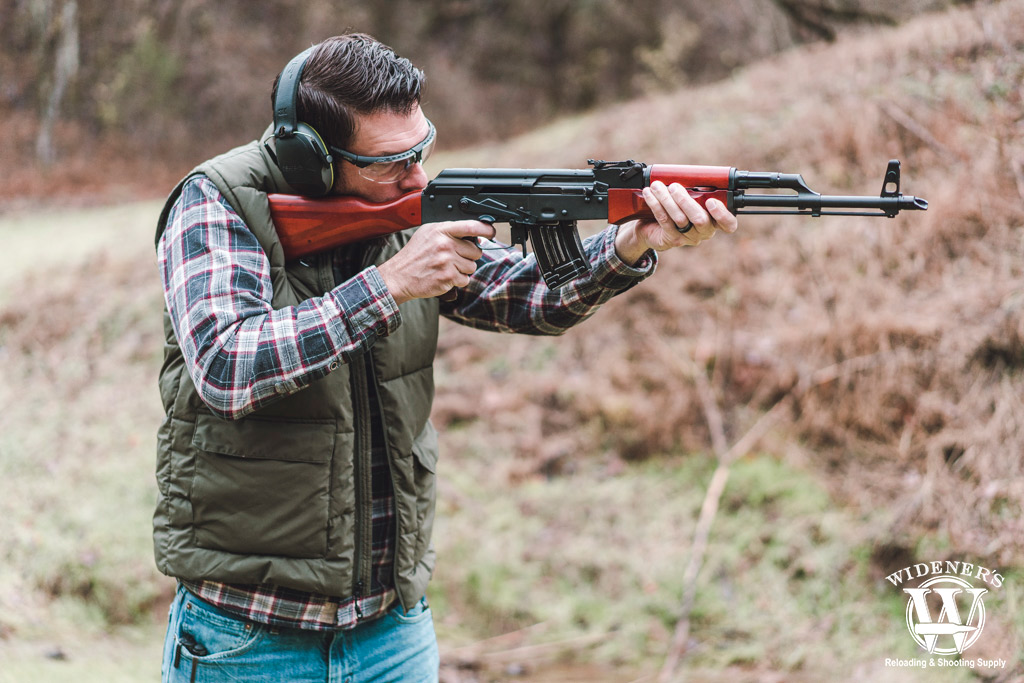 a photo of a man shooting an ak-47 rifle