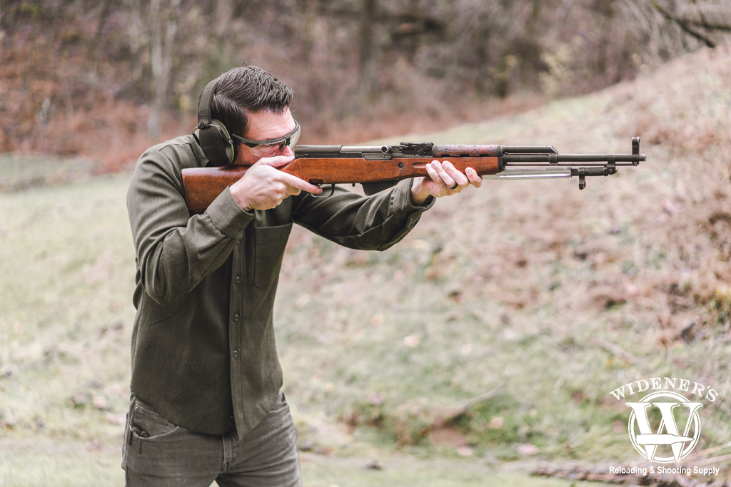 a photo of a man shooting an SKS rifle at the gun range
