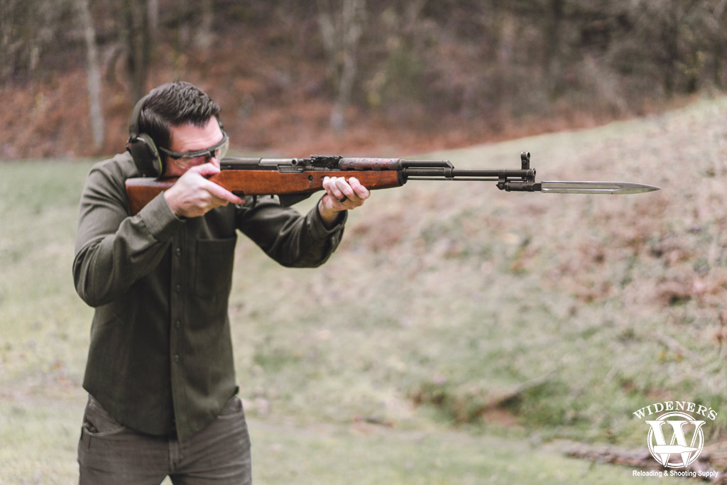 a photo of a man shooting an SKS rifle