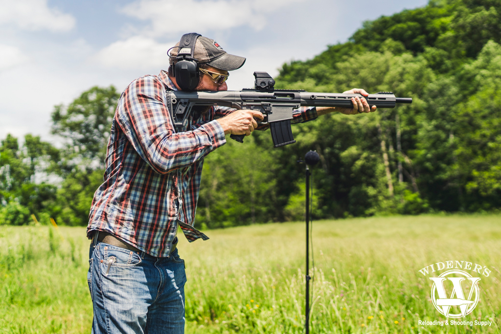 a photo of a man shooting a shotgun