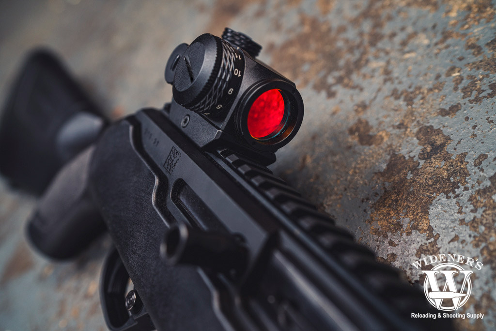 a photo of a red dot optic on a picatinny rail 