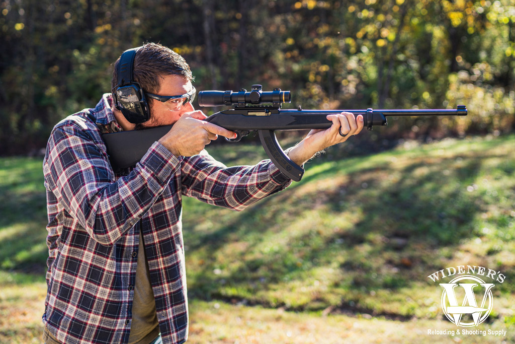 a photo of a man shooting a rimfire rifle