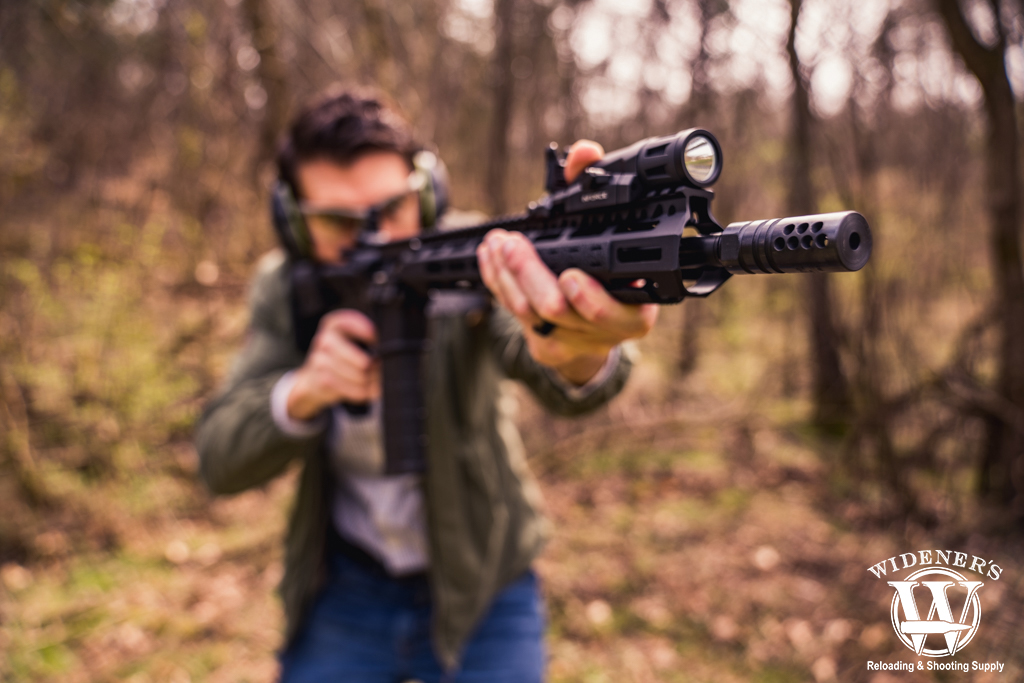 photo of a man shooting an ar-15 rifle outdoors