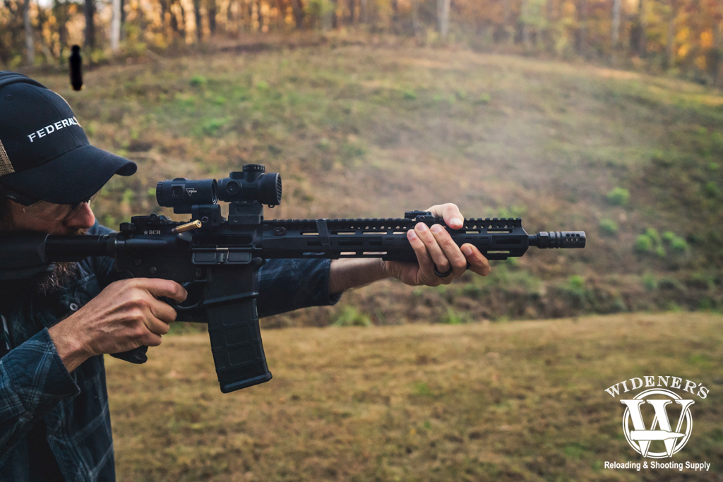 man shooting a rifle with a compensator a man shooting a rifle with a compensator
