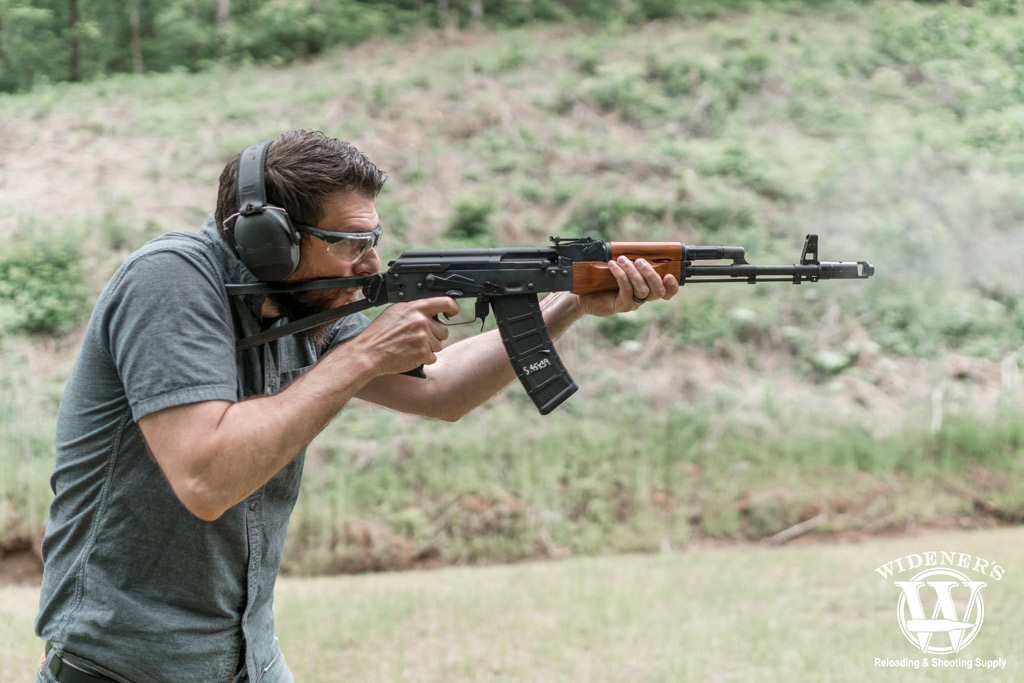 a photo of a man shooting an ak-74 rifle 