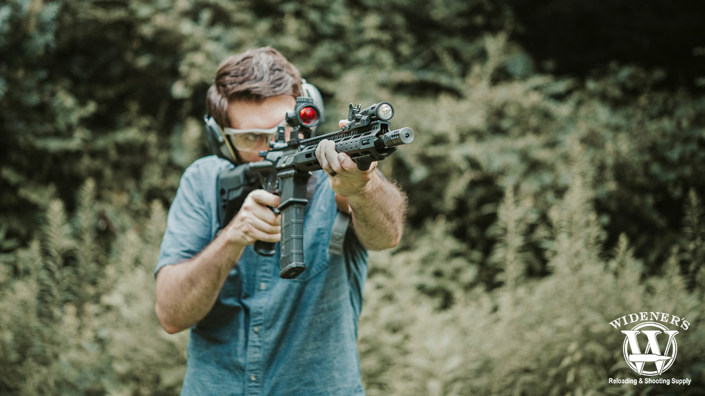 a photo of a man shooting an ar-15 rifle