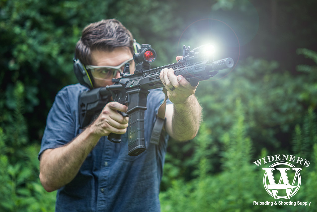 A photo of a man shooting an ar-15 rifle outdoors