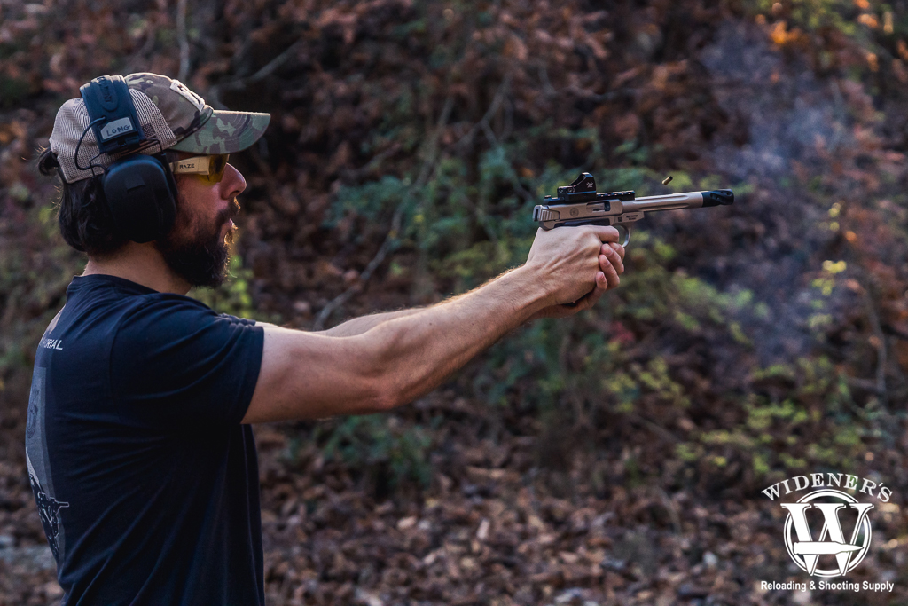 man shooting a compensated smith & weson 22 victory pistol a photo of a man shooting a compensated smith & weson 22 victory pistol