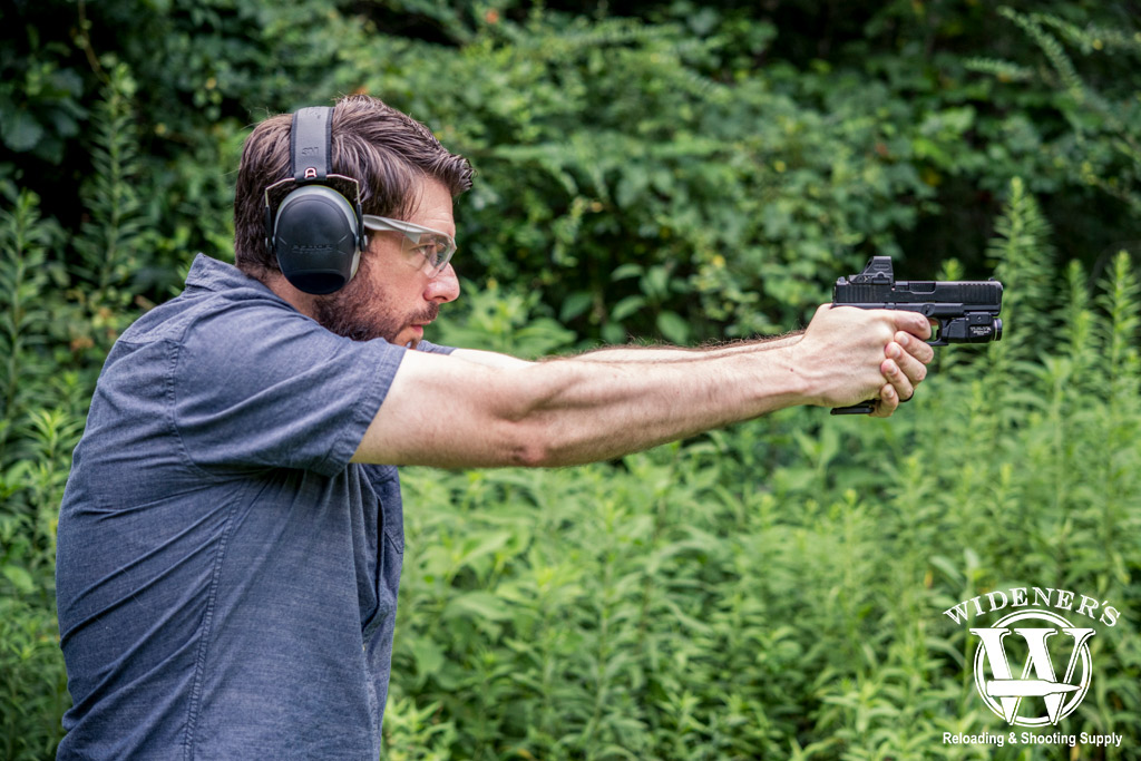 a photo of a man shooting a 9mm glock handgun