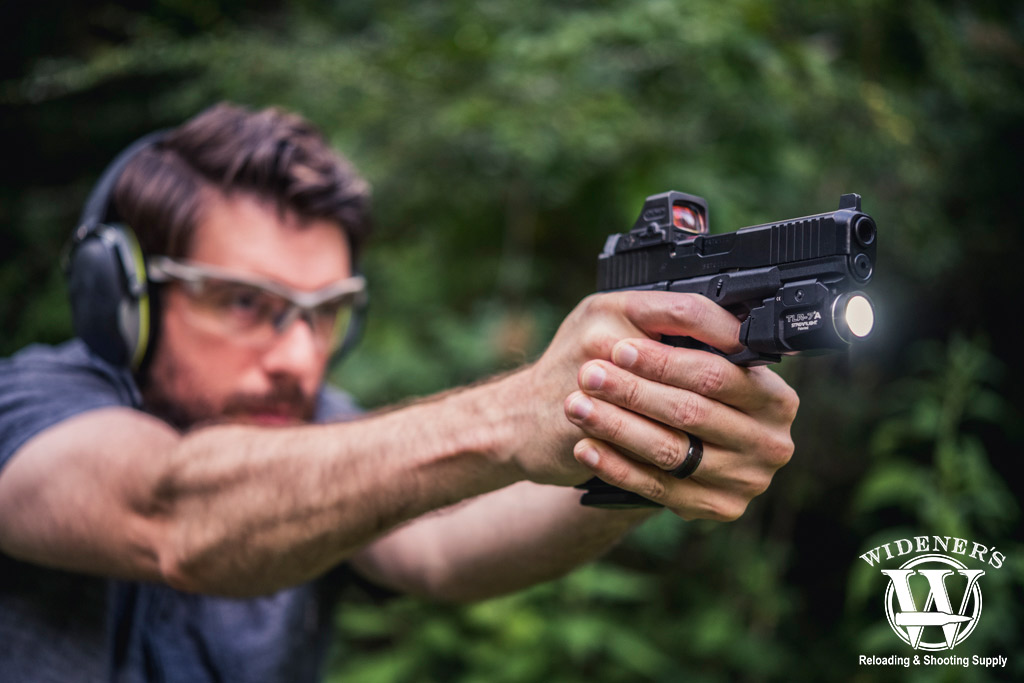 a man shooting a glock pistol at a gun range