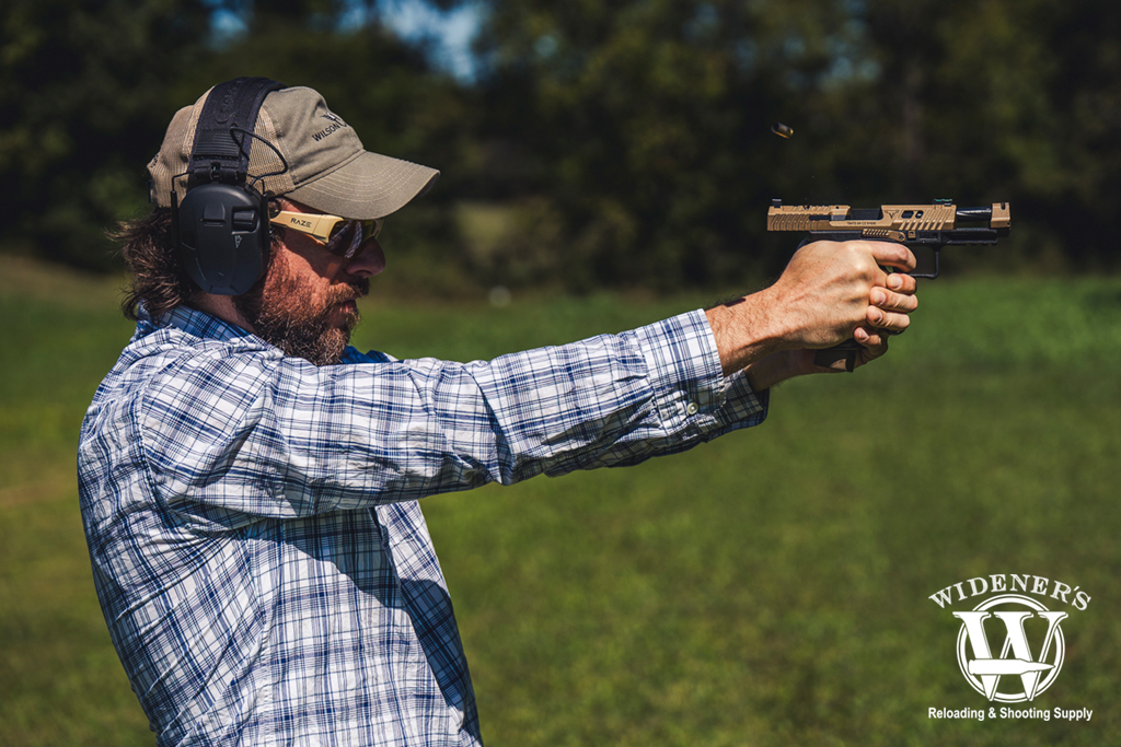 man shooting a handgun with a compensator a photo of a man shooting a handgun with a compensator