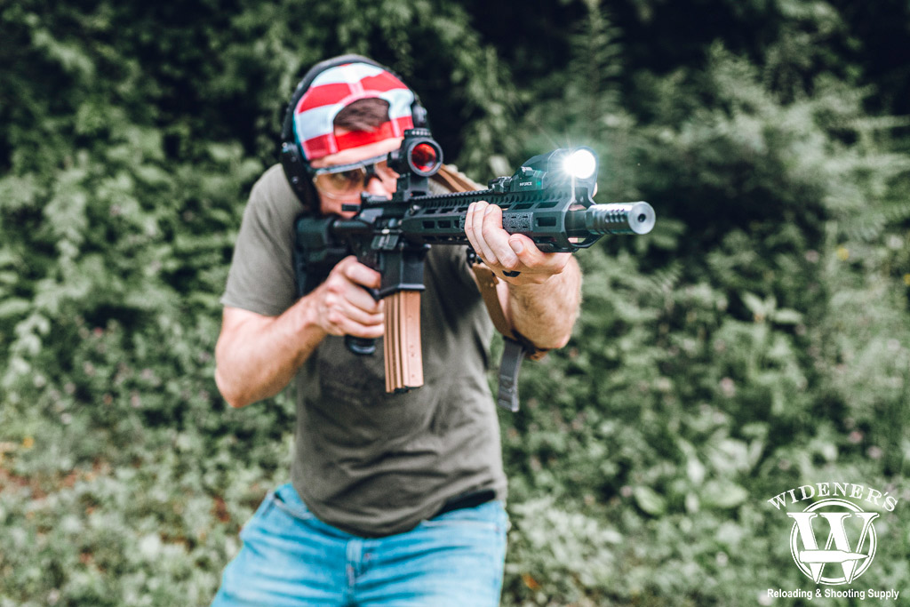 a photo of a man shooting an ar-15 rifle