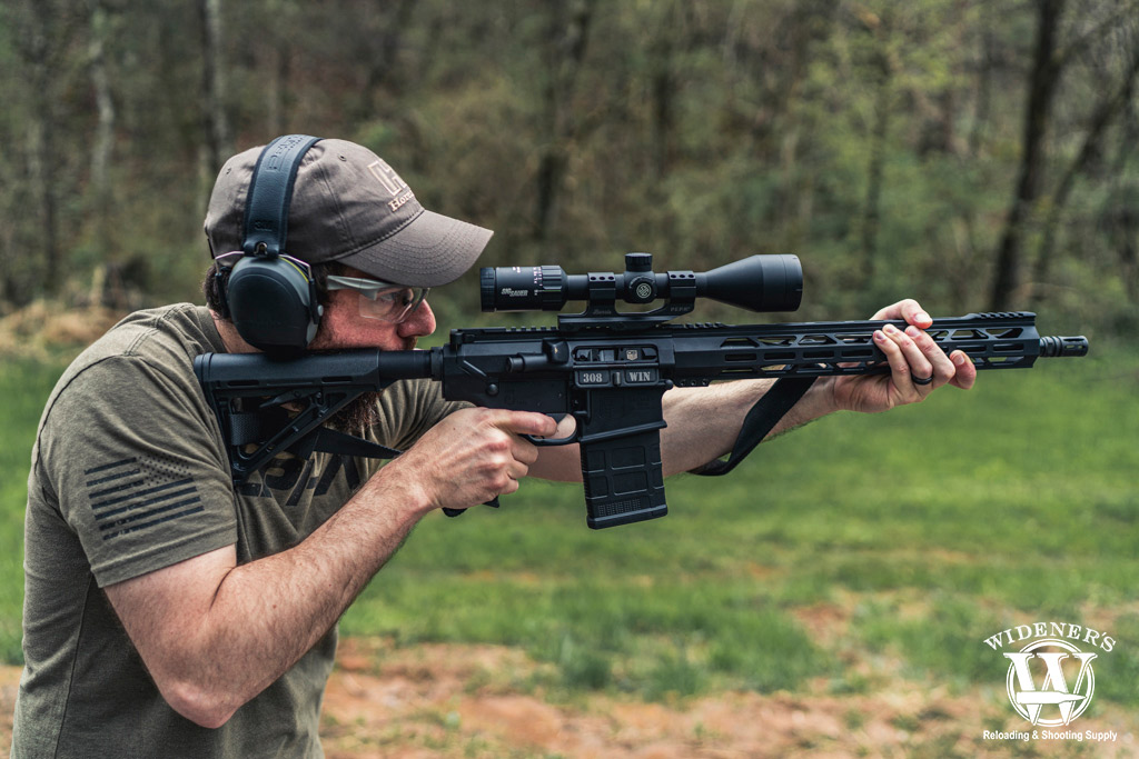 a photo of a man shooting an ar-10 rifle