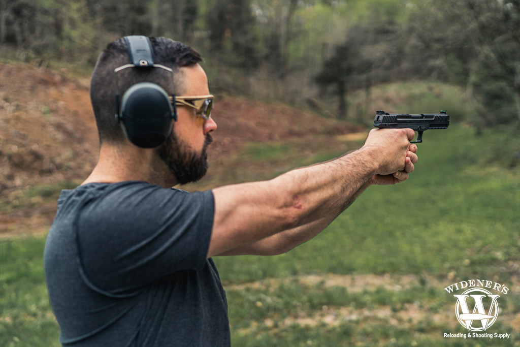 a photo of a man shooting a ruger 57 pistol at a gun range