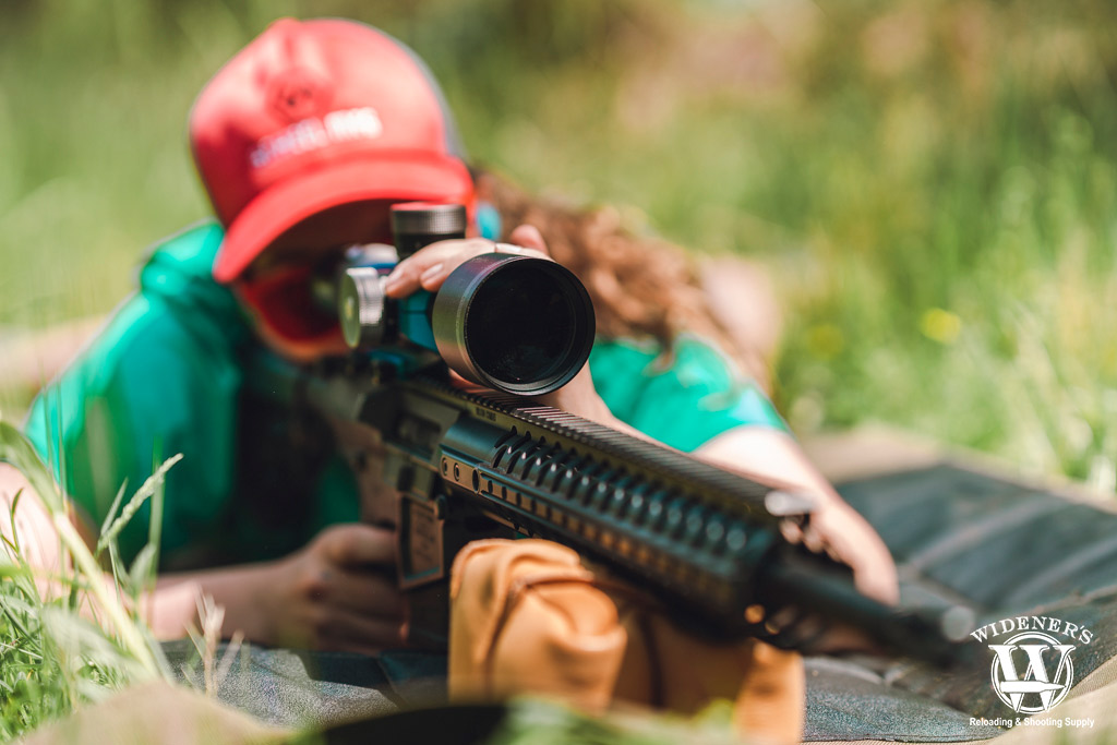 a photo of a woman shooting an ar-10 semi auto rifle