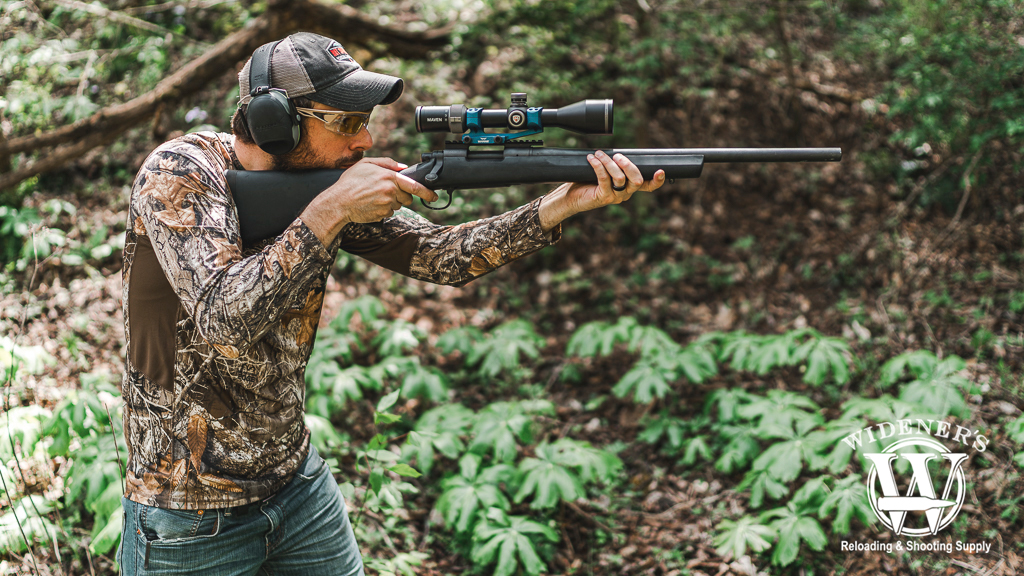 a photo a man shooting a remington 700 rifle in the woods