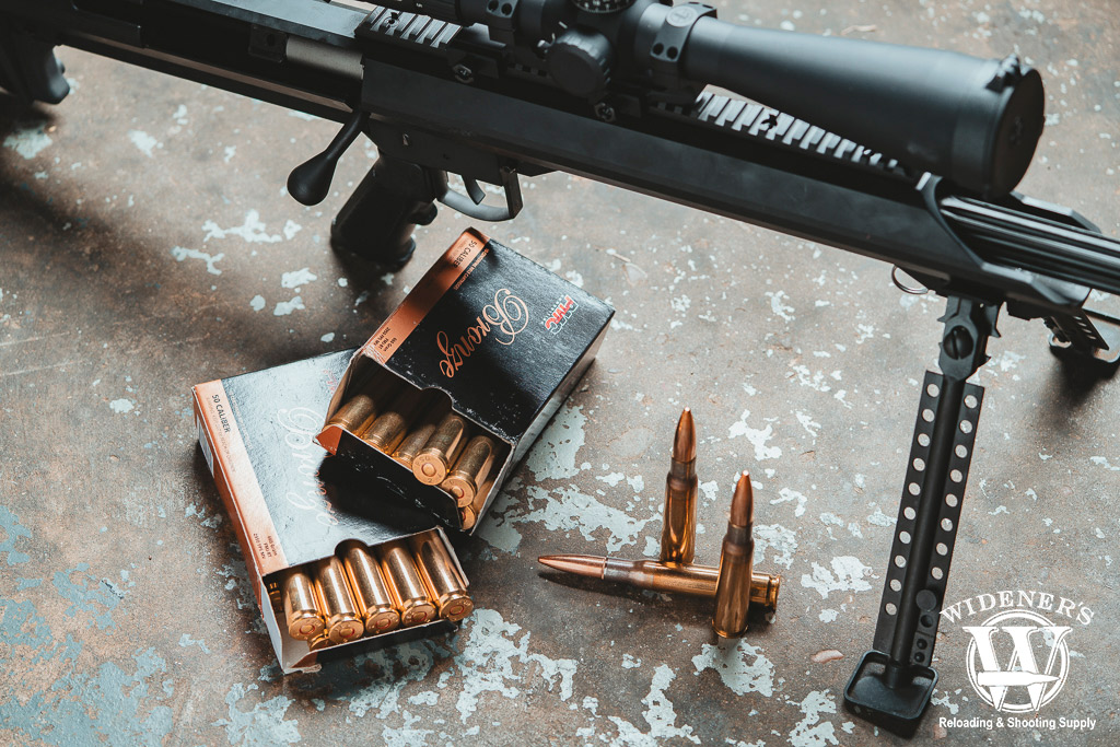 a photo of PMC .50 BMG ammo with a bolt action rifle