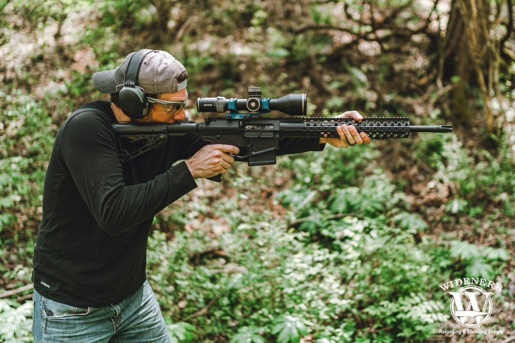 A photo of a man shooting an ar-10 rifle