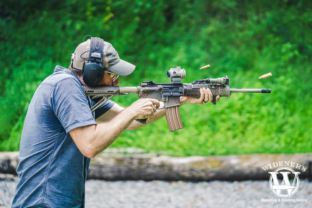 a photo of a sweaty man shooting a rifle at the gun range