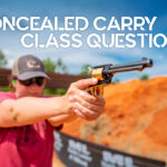 a photo of concealed carry class instructor firing a pistol at an outdoors gun range
