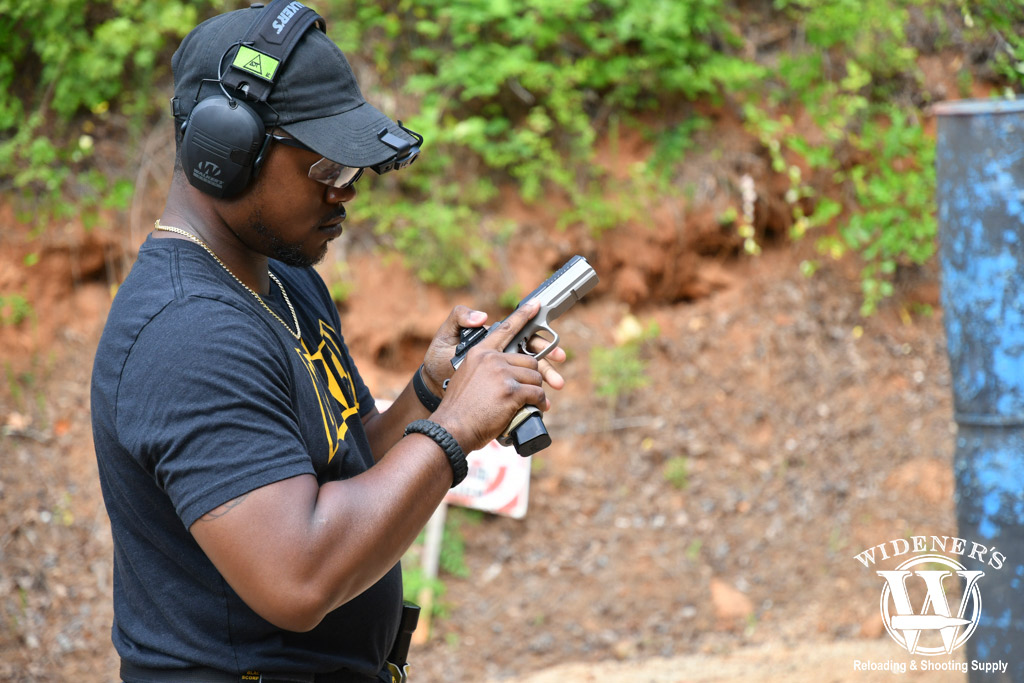 a photo of a man safely handing a gun at the range