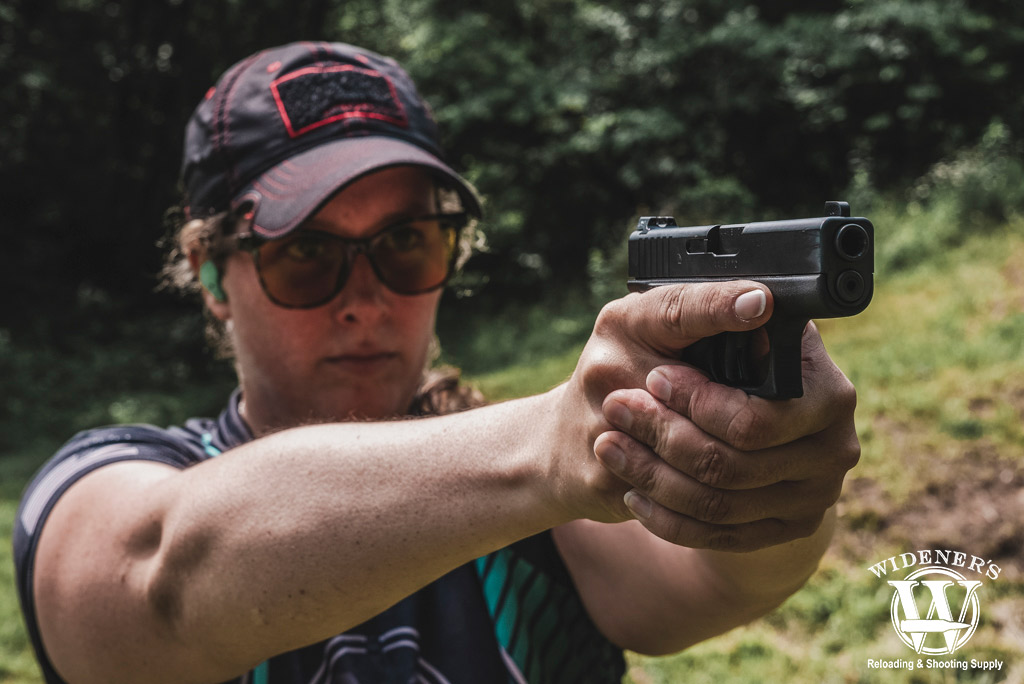 a photo of a woman shooting a subcompact handgun at the range