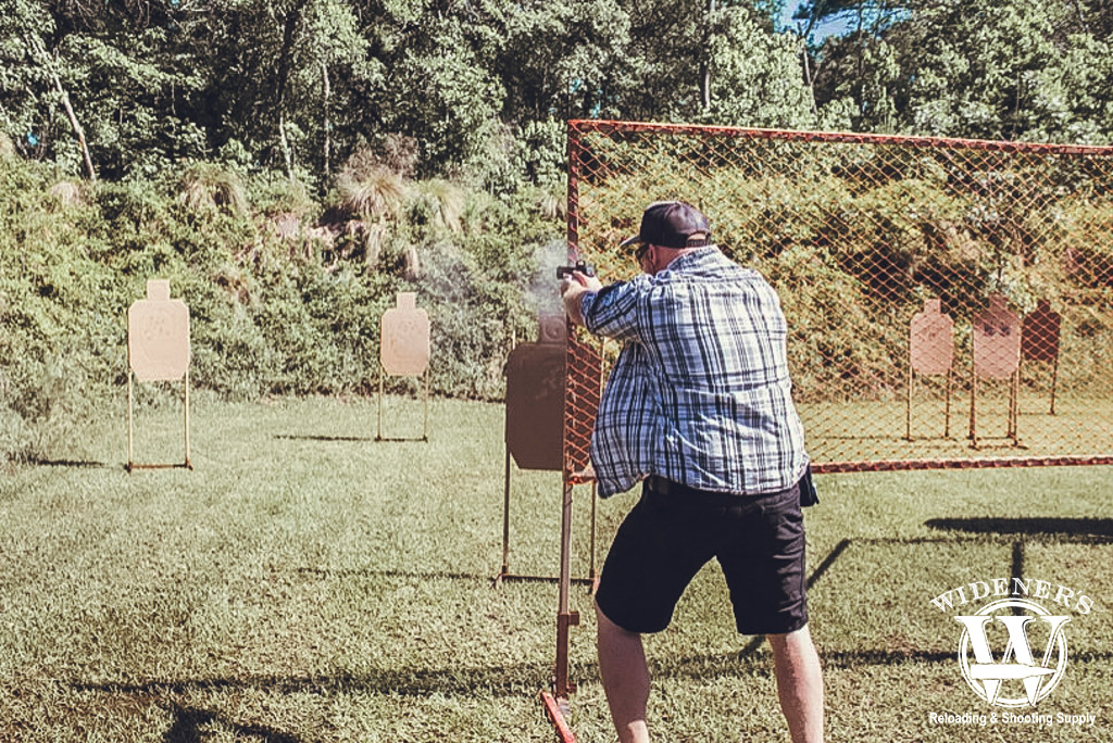 a photo of a man at an idpa shooting competition